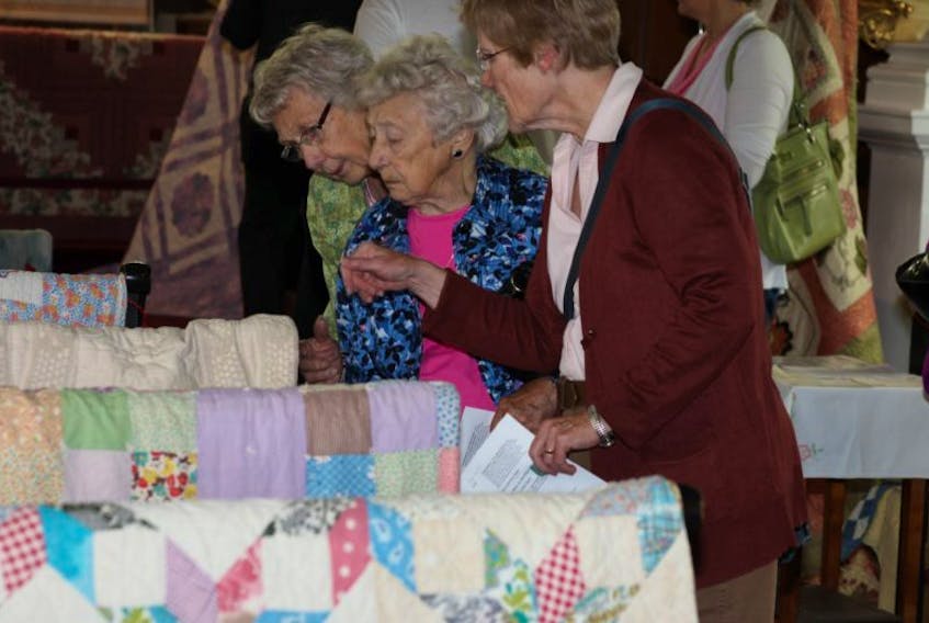 Visitors check out some of the quilts on display at the 'Blessed are the Piecemakers' quilt show, tea and sale at St. Mary's Anglican Church in Auburn. The show, which features a number of heritage quilts as well as music and demonstrations on quilts and quiltmaking, runs until 4 p.m. today and again from 10 a.m. to 4 p.m. on Saturday.