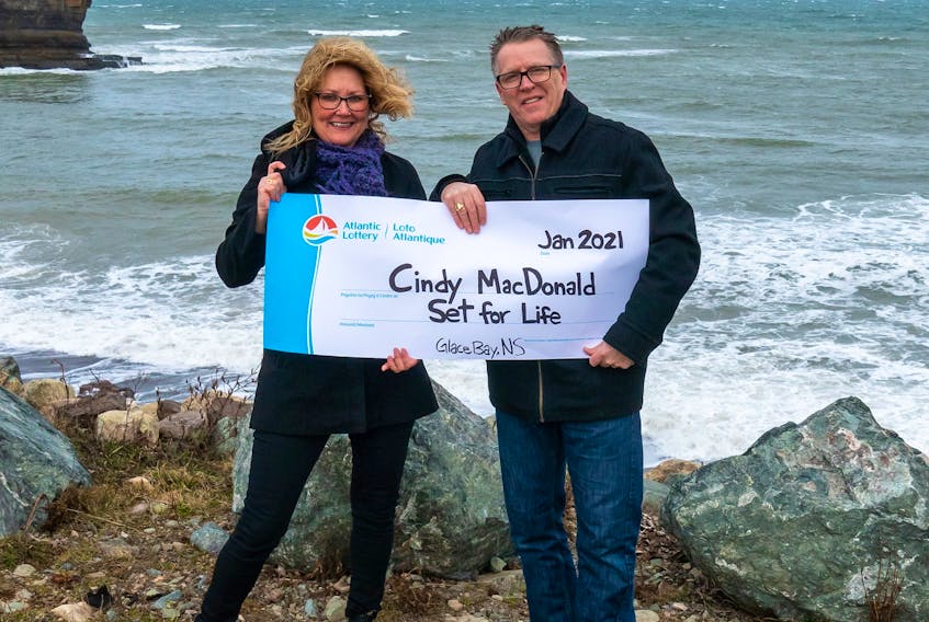 Cindy MacDonald poses with her husband Joe, while holding an Atlantic Lottery Corp. "cheque" naming her a top prize winner of a Set for Life Scratch ‘N Win ticket. The Glace Bay woman said she has opted for the $1,000 a week payout for 25 years instead of the lump payment of $625,000. CONTRIBUTED