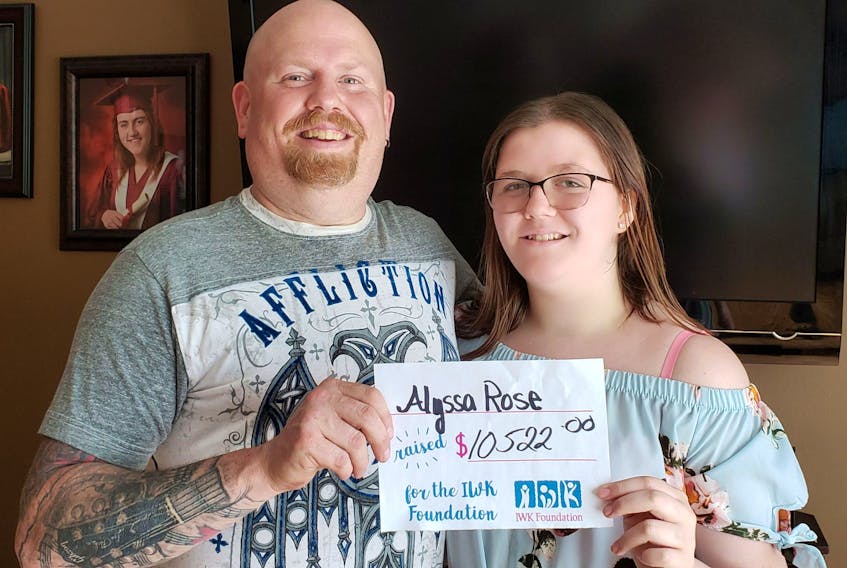 Alyssa Rose shows off a cheque for the IWK Health Centre with her father Shawn at their Point Edward home recently. Rose, 14, started raising money for the IWK Telethon last year after needing the Halifax hospital's services to remove a brain tumour. This year's total of $10,522 is one dollar more than last year's donation. Rose raised money through a raffle draw on a gift basket and a $1,200 donation from That's Right Roofing of Sydney, which pushed the donation over the top. CONTRIBUTED 