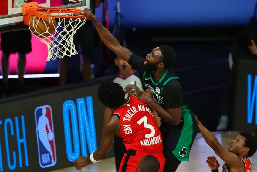 Boston Celtics guard Kemba Walker (top) dunks over Toronto Raptors forward OG Anunoby (3) during Ggame 5 Monday at ESPN Wide World of Sports Complex.