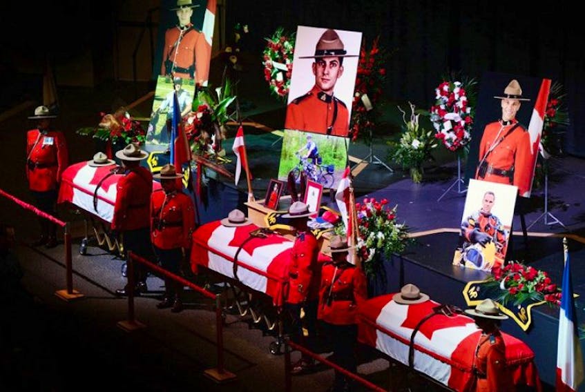 The caskets of Const. Dave Joseph Ross, 32, from Victoriaville, Que., left to right, Const. Douglas James Larche, 40, from Saint John, N.B. and Const. Fabrice Georges Gevaudan, 45, from Boulogne-Billancourt, France, sit in Wesleyan Celebration Centre during the public visitation in Moncton, N.B. on Monday. A regimental funeral will take place Tuesday for the three RCMP officers who were slain in Moncton last week.&nbsp;