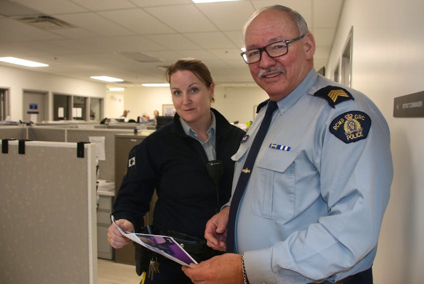 Constable Lori Thorne and Staff Sergeant Allan Carroll, of the Colchester District RCMP, are two of the officers trying to protect people against scammers by sharing printed information such as ‘The Little Black Book of Scams.’ March is fraud prevention month. LYNN CURWIN/TRURO NEWS