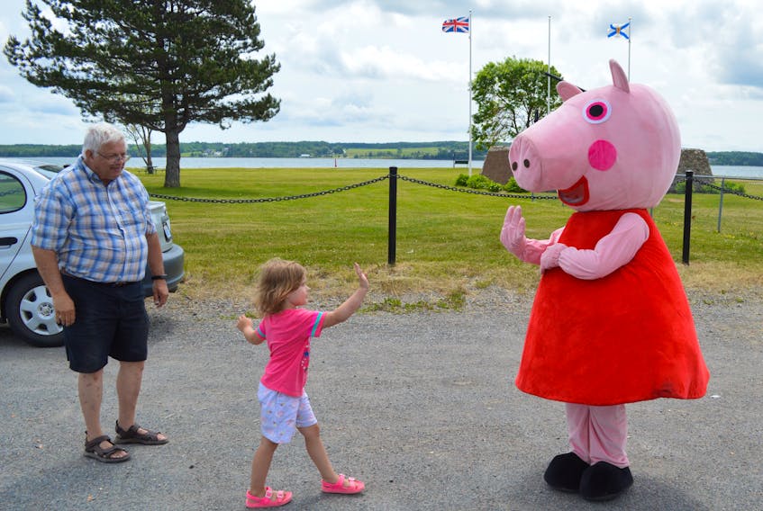 After a brief hesitation and some encouraging words from her grandfather Jack Reid, Aubrey Reid, centre, approaches British television character Peppa Pig at Munro Park in North Sydney on Sunday. After high-fiving Peppa Pig, the almost four-year-old then turned to Minnie Mouse, who was waiting nearby for a big hug. The Reids were among many Cape Breton Regional Municipality residents who took advantage of Sunday’s fine weather to enjoy time outdoors. DAVID JALA • CAPE BRETON POST