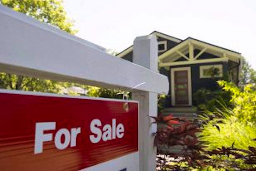['A for sale sign is pictured outside a home in Vancouver in a June, 28, 2016, file photo.']