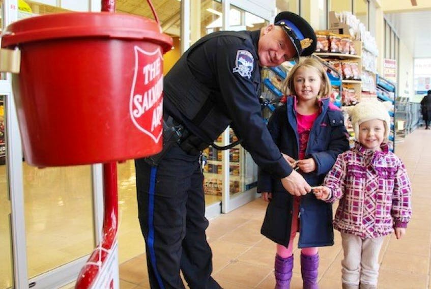 <p>Walter Smith with the New Glasgow Regional Police Department offers Ava Chisholm, centre, and Addison Dunphy a candy cane while he volunteers at the Salvation Army’s Red Kettle at the Atlantic Superstore. The Red Kettle campaign is a large fundraiser for the Salvation Army and will end Thursday.</p>
Sueann Musick – The News