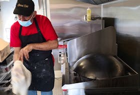 Jankez Wanli, a refugee from Syria who works at the Global Eats food truck, tosses the dough for a Saj, before frying it on an upside-down wok. Saj is a type of Middle Eastern flatbread, similar to a tortilla, and often used as a wrap for shawarma. – Andrew Waterman/The Telegram