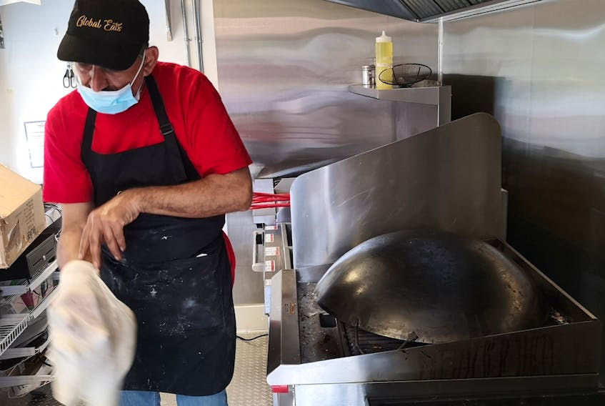 Jankez Wanli, a refugee from Syria who works at the Global Eats food truck, tosses the dough for a Saj, before frying it on an upside-down wok. Saj is a type of Middle Eastern flatbread, similar to a tortilla, and often used as a wrap for shawarma. – Andrew Waterman/The Telegram