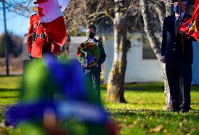Ethan Gunn stands with a wreath during the Remembrance Day ceremony in Morell.