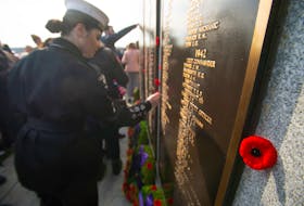 People place poppies on the Sailors' Memorial following the annual Remembrance Day ceremony at Point Pleasant Park on Monday.