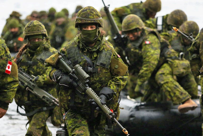 Reservists in full tactical gear exit an assault boat during a landing exercise at CFB Kingston in 2018. Part-time soldiering makes Canada's reservists among the best and smartest citizens, Christie Blatchford writes.