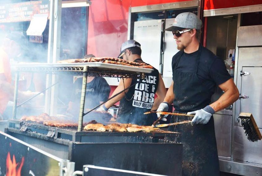 <p>David Robichaud, a member of the Billy Bones ribber crew, worked to ensure ribs and other items on the grill got out quickly to those in line, Sunday afternoon at Sydney Ribfest.</p>