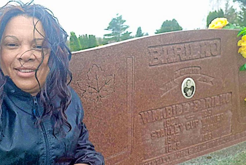 Tracey Riley sits in front of Bill Barilko’s headstone in Timmins, Ont. On Thursday she cleaned Barilko’s headstone at the request of her father, Bill Riley.
