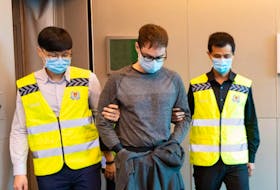David James Roach, 30, of River Ryan is escorted into court in Singapore Tuesday, where he was charged with robbery and money laundering. Roach was extradited from London, England to Singapore on Monday, accused of robbing a bank in Singapore on July 7, 2016. Contributed/Singapore Police Force