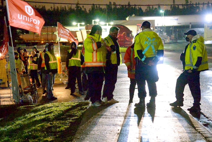 Police speak to union leadership before the picketers allowed trucks to leave the Weston Bakery lot in Mount Pearl Wednesday night. Keith Gosse/The Telegram