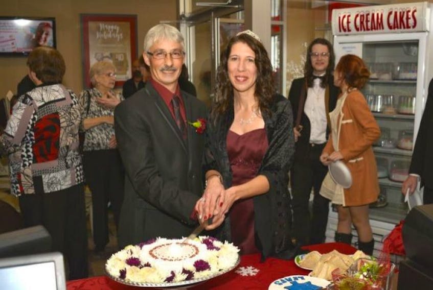 Robert and Lisa Langille cut their wedding cake in the Amherst Robin's Donuts shop Saturday.