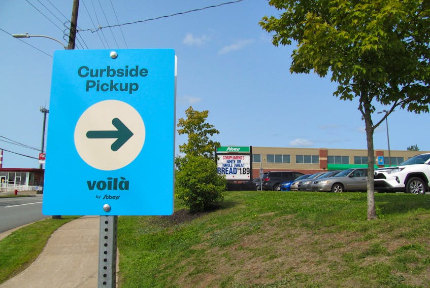 Empire Co. Ltd. is expanding its e-commerce offering with the launch of Voilà by Sobeys curbside pickup at three locations in Nova Scotia. A sign at the driveway of the Sobeys on Wyse Road in Dartmouth points the way for shoppers.