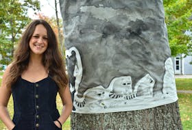 Artist Ashley Anne Clark stands next to her contribution to Rooted in Art, a tree appreciation initiative by the City of Charlottetown. Inspired by the red oak it's wrapped around, the artwork features animals which use acorns as a food source, including some no longer present in P.E.I.