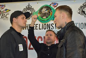 Vladimir Reznicek of the Prague, Czech Republic, left, stares down Ryan Rozicki of Sydney Forks while Three Lions Promotions managing director Daniel Otter holds up the WBC International Silver Cruiserweight Championship belt on Wednesday at Centre 200. The two fighters will square off for the belt on Friday at the Valentine’s Day Massacre fight card at Centre 200 in downtown Sydney. CAPE BRETON POST