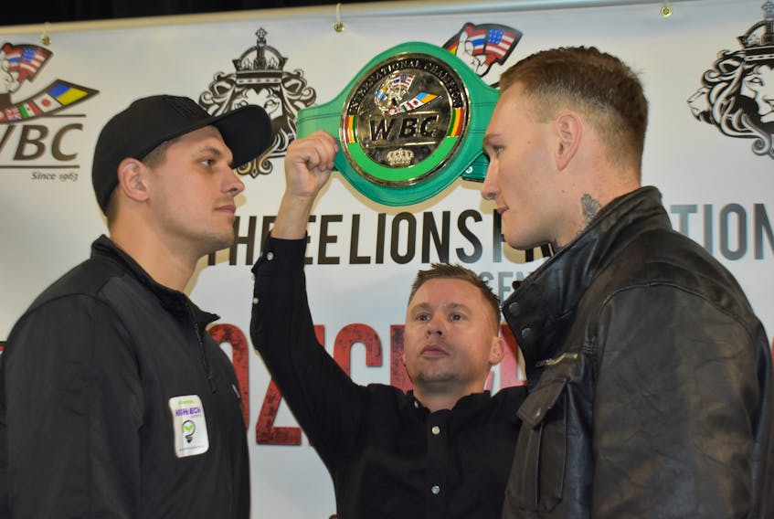 Vladimir Reznicek of the Prague, Czech Republic, left, stares down Ryan Rozicki of Sydney Forks while Three Lions Promotions managing director Daniel Otter holds up the WBC International Silver Cruiserweight Championship belt on Wednesday at Centre 200. The two fighters will square off for the belt on Friday at the Valentine’s Day Massacre fight card at Centre 200 in downtown Sydney. CAPE BRETON POST