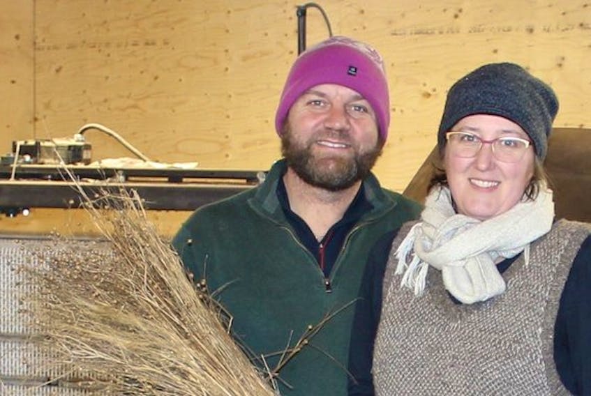 Josh Oulton and Patricia Bishop, of Taproot farms in Port Williams, are shown with farm machinery designed to harvest fibres from harvested flax plants. They hope flax will be spun into fibres to make clothing and other linen products.