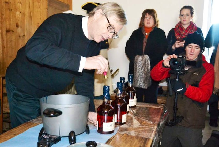 FILE PHOTO - Glynn Williams, president of Authentic Seacoast Company, added a fleur-de-lis stamp to the top of a bottle of Fortress Rum, as the product was launched at the Fortress of Louisbourg in February.