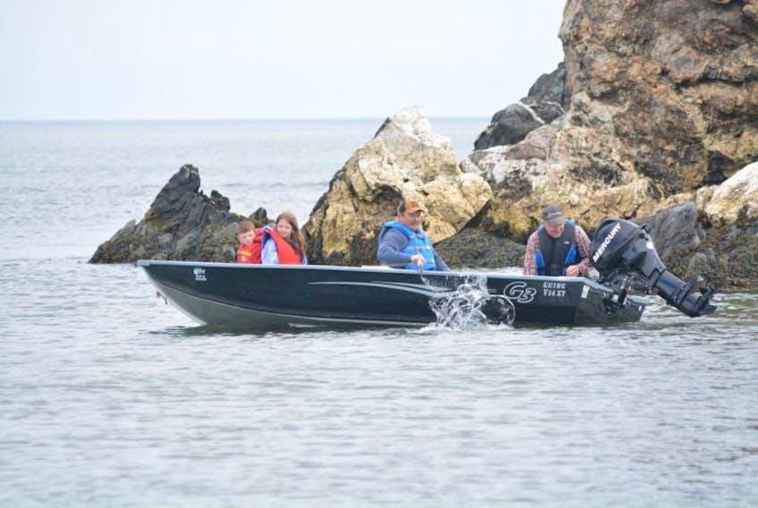 With the recreational food fishery in full swing, this quartet launched their boat from the beach and went off in search of cod. While waiting for Wade Penney (right) to get the motor started, Corey Layman (centre) paddles while his children Jax and Lanie Layman take a look around.