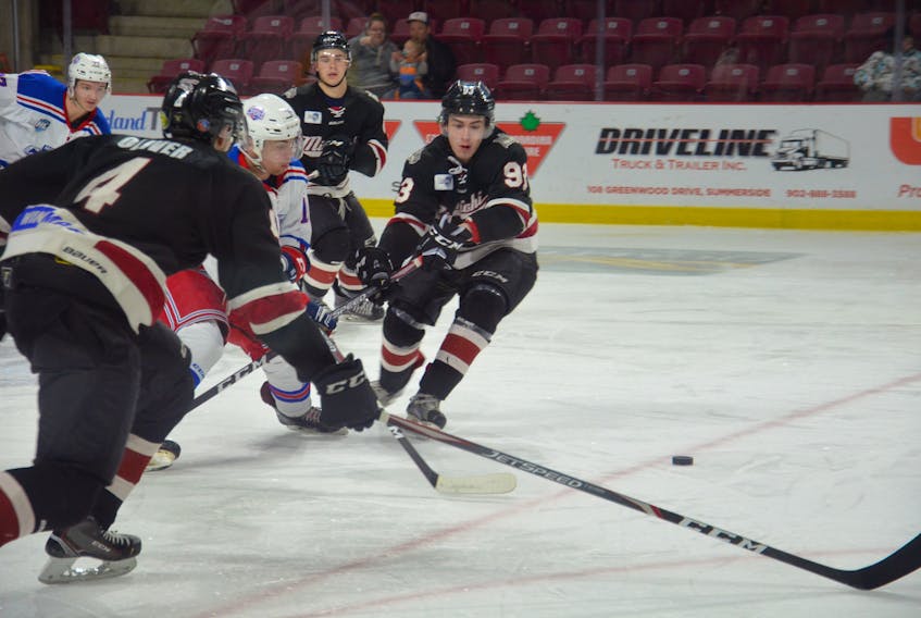 Summerside Western Capitals forward Riley MacDougall attempts to split two Miramichi Timberwolves defenders, Mike Oliver, 4, and Jarrett Wood, 93, during Thursday night’s Maritime Junior Hockey League game at Eastlink Arena. The Caps won the contest 9-4.