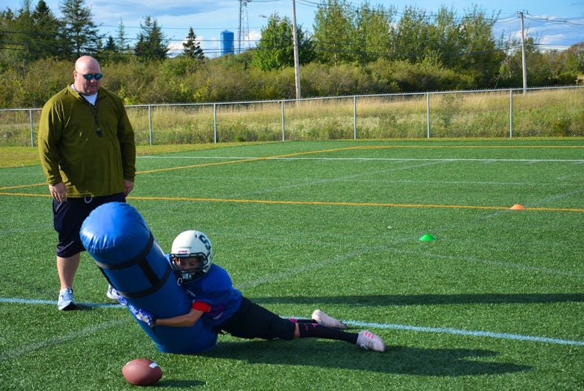 Christian Cameron of the Summerside Spartans’ atom team completes a drill under the watchful eye of coach Mike Millar during a recent practice at Eric Johnston Field in Summerside.