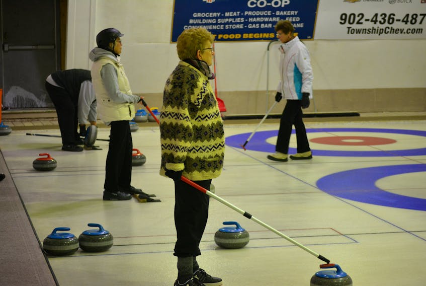 Audrey Callaghan, foreground, and Bernie Field await direction from their teammates at the opposite end of the sheet while Frances Ellsworth returns to her hack after delivering a stone during round-robin play in the P.E.I provincial stick curling championships at the Maple Leaf Curling Club in O’Leary.