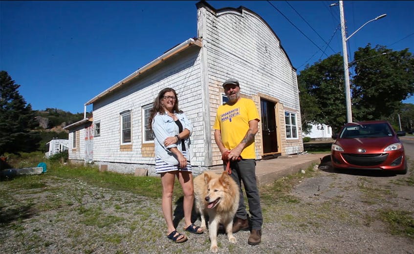Kym McWhirter and Andy Hawkins with their pooch, Akaya in front of an old store they're renovating in Centreville, Digby Neck. They plan to open up a retail shop and workshop for McWhirter's pottery in the front with a living space and office in the back.

TIM KROCHAK PHOTO