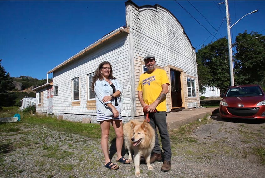 Kym McWhirter and Andy Hawkins with their pooch, Akaya in front of an old store they're renovating in Centreville, Digby Neck. They plan to open up a retail shop and workshop for McWhirter's pottery in the front with a living space and office in the back.

TIM KROCHAK PHOTO