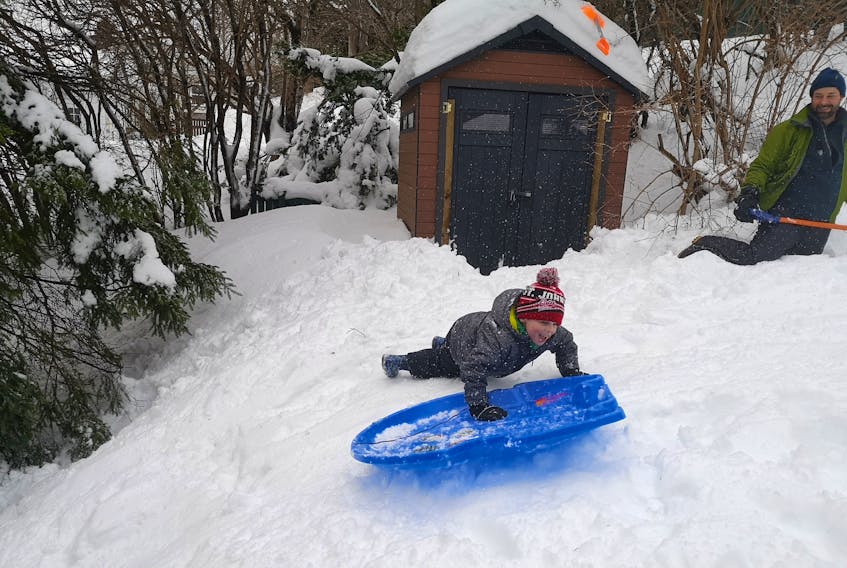 Ben Walsh has his turn sliding down the hill in the backyard of his neighbour's house. Andrew Waterman/The Telegram