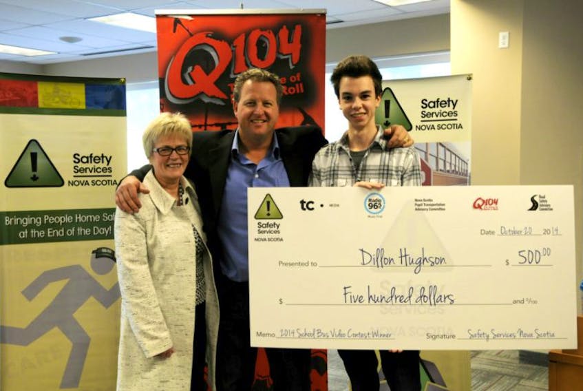 <p>Anita DeLazzer, publisher and general manager of the Cape Breton Post, and BJ Wilson from Q104, honour Dillon Hughson, winner of the School Bus Safety Week video contest.</p>