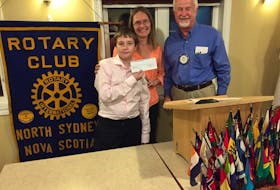 Zavier Bond and his mother Lisa Bond accept a second $500 contribution from Mike Johnson of the Rotary Club of North Sydney for the T.L. Sullivan Caring Closet. The program was initiated last year at the Florence school by the Bonds to provide clothing, school supplies, hygiene products and hot lunches to students who might otherwise not have access. CONTRIBUTED