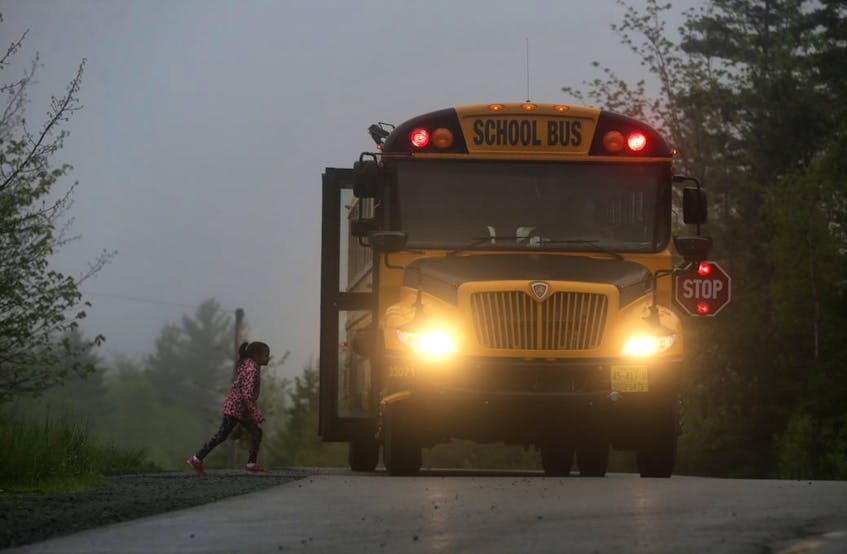 A young child boards a school bus on a dark, foggy morning near Lake Loon (Dartmouth) in this file photo. - Contributed