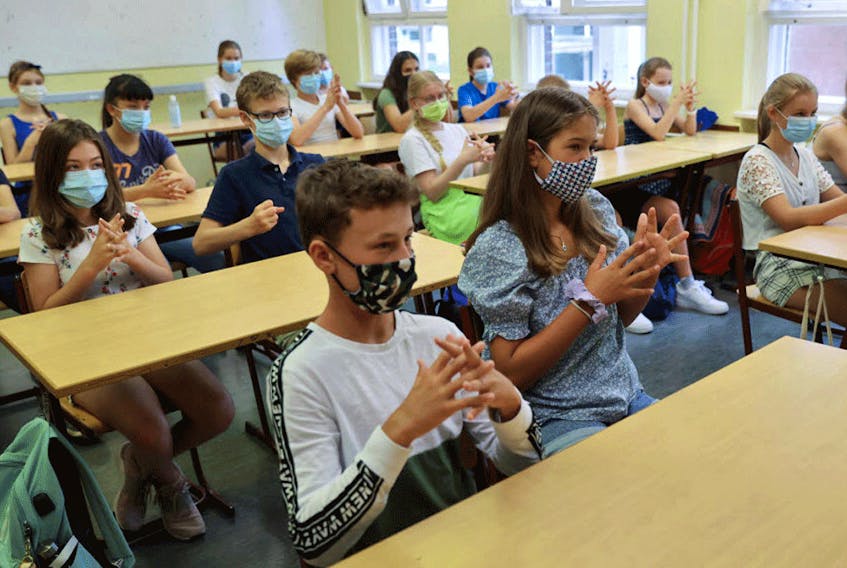 Students at a Berlin high school practise hand disinfection, August 10, 2020. Researchers have explored how different combination of class sizes and time in class could affect potential COVID-19 outbreaks.