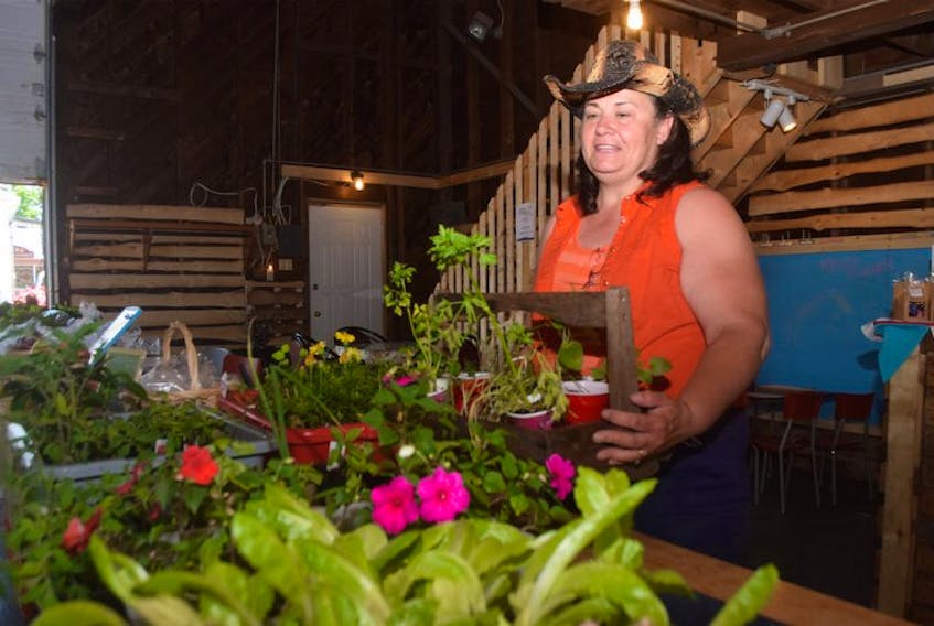 Eleanor Fifield, manager of Deb &amp; Al’s Farmer’s Market in Scotsburn, prepares a table on Saturday. KEVIN ADSHADE/THE NEWS