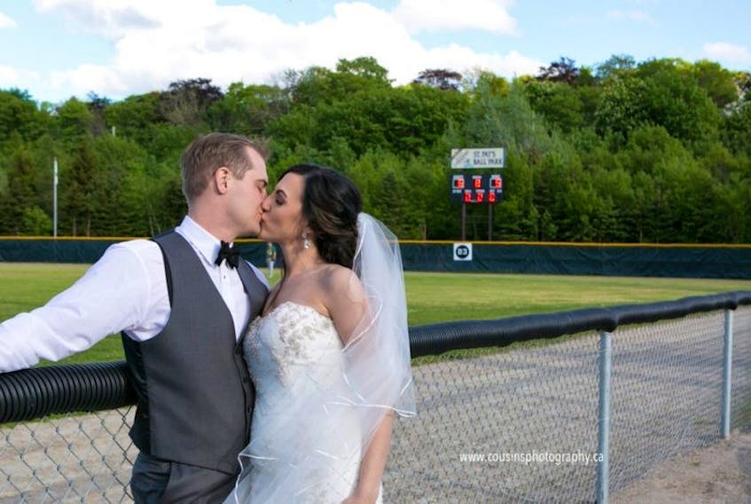Newlyweds Scott Stockley and Joanne Buckingham share a kiss at St. Pat's Ball Park on Saturday. The pair had wedding photos taken on the infield during an intermediate league game that went long.