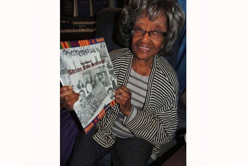 Aleta Williams displays a copy of The Times of African Nova Scotians, which tells the story of Viola Desmond. She will be the first Canadian woman to appear on the front of a regularly circulating bank note.