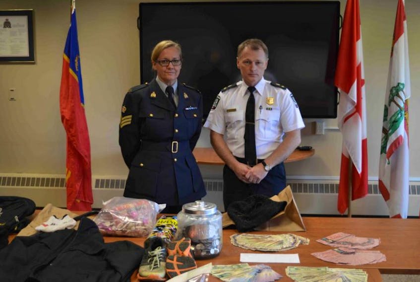 RCMP Sgt. Leann Butler and Charlottetown Police Services Deputy Chief Brad MacConnell stand behind some of the items a joint task force recovered from the thief that has become known as the screencutter. Richard Joseph Arsenault, who entered a not-guilty plea in early November in this case, goes to trial Tuesday in Charlottetown.