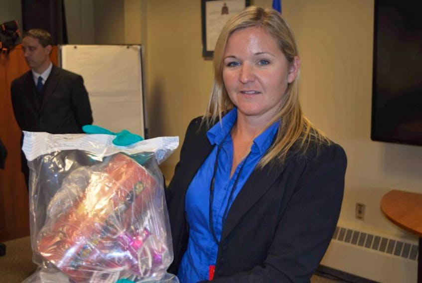 <p>RCMP Const. Tara McBride displays a child’s piggybank on Wednesday that was recovered by a joint RCMP/Charlottetown Police Services task force into the so-called ‘screencutter’ case.</p>