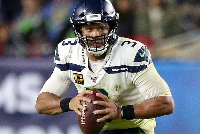 Seattle Seahawks quarterback Russell Wilson drops back to pass over the defense of the Los Angeles Rams at Los Angeles Memorial Coliseum on Dec. 8, 2019, in Los Angeles.