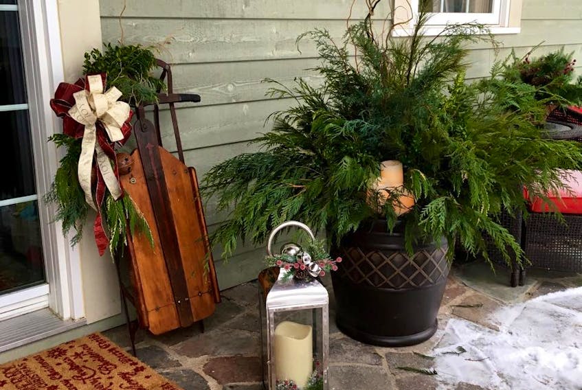 Add holiday sparkle to your front door with a beautiful planter filled with greenery, branches, berries and decorative accents like bows or ornaments. Crystal Godfrey, Secret Garden by Crystal