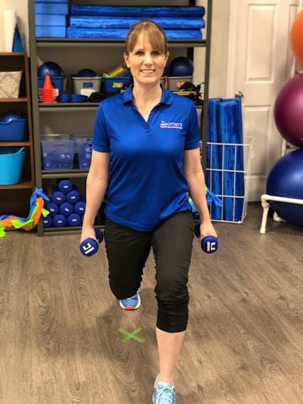 Physiotherapist Laura Lundquist demonstrates a walking lunge with weights, illustrating the importance of building strength. 