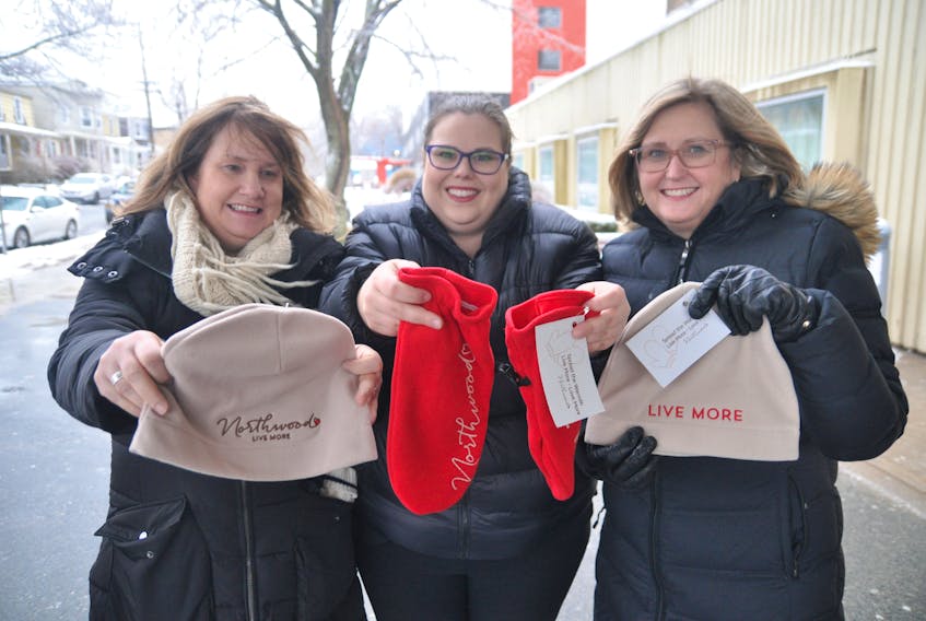 Northwood employees (from left) Shelley James, Jennifer Main and Caroline Campbell led a people services team along Gottingen Street in Halifax and pinned hats and mittens for anyone in need to take and use. It was part of the organization’s first Spread the Warmth campaign. Sara Ericsson