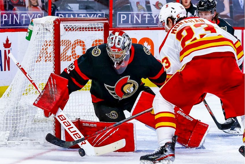 Ottawa Senators goaltender Filip Gustavsson makes a save against Calgary Flames centre Sean Monahan during second-period action at the Canadian Tire Centre.