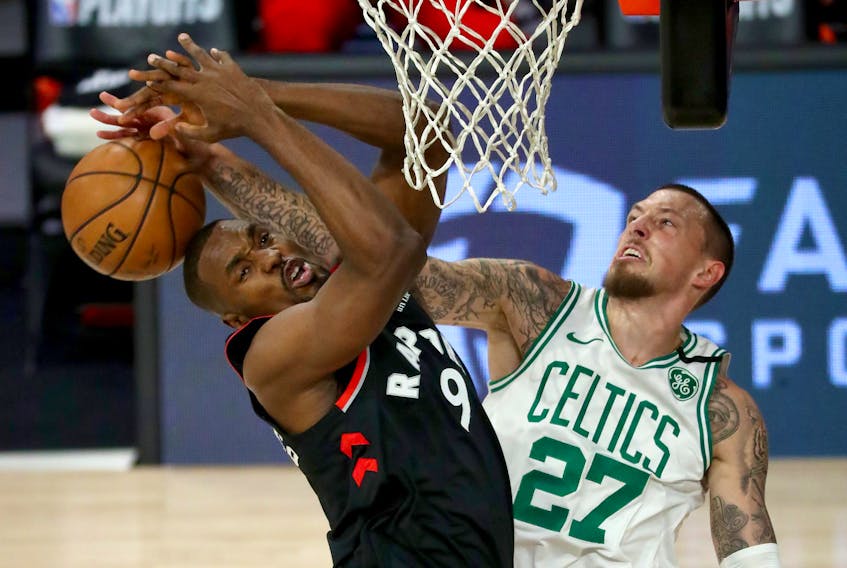 Raptors’ Serge Ibaka (left) is blocked by Celtics’ Daniel Theis during Game 4 on Saturday night in Lake Buena Vista, Fla. 