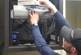 Michael McKinnon, senior technician with Devantec IT and Security, installs a firewall to allow a company's employees to work remotely from home. CONTRIBUTED
