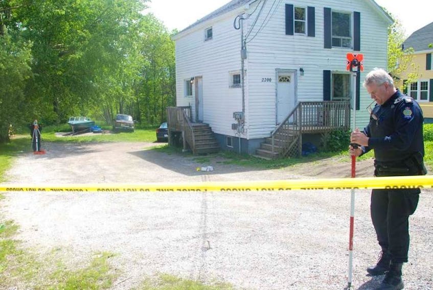 Sgt. Geoff MacLeod, right, of the Cape Breton Regional Police Services' forensic identification unit, and Const. Ed Hall, in back on left, take measurements on the property at 2200 Sydney Road, while investigating the shooting that killed a 24-year old man Thursday evening.&nbsp; A 25-year old Ben Eoin area man was arrested in Dartmouth early Friday morning in connection with the fatal shooting.