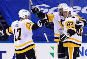 Pittsburgh Penguins defenceman P.O. Joseph, centre, celebrates with Sidney Crosby, right, and Brian Rust after Joseph set up Crosby for the overtime winner against the New York Rangers on Saturday. (PITTSBURGH PENGUINS)
